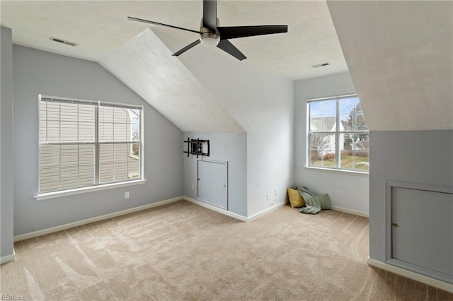 additional living space featuring ceiling fan, lofted ceiling, and light carpet