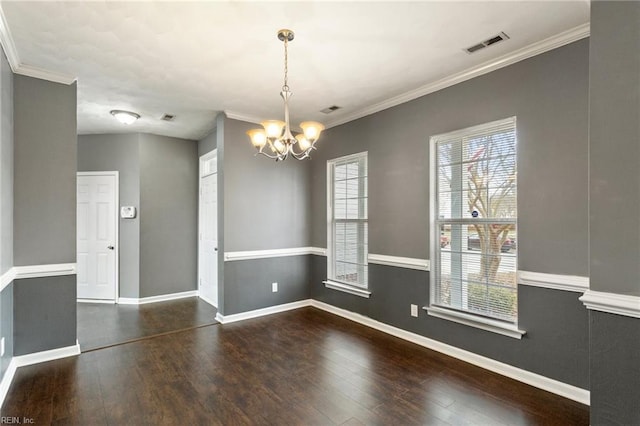 unfurnished dining area featuring dark hardwood / wood-style flooring, ornamental molding, and an inviting chandelier