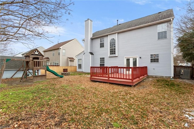 back of house with a playground, a wooden deck, cooling unit, and a lawn