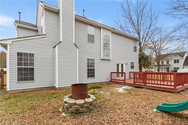 rear view of property with a fire pit and a wooden deck