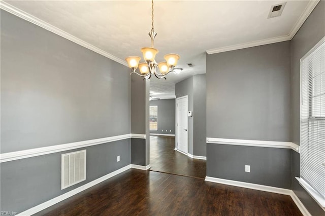 empty room featuring dark wood-type flooring, ornamental molding, and an inviting chandelier