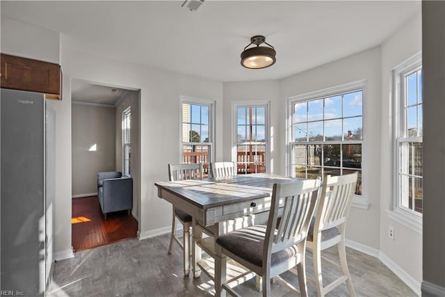 dining area featuring light wood-type flooring and plenty of natural light