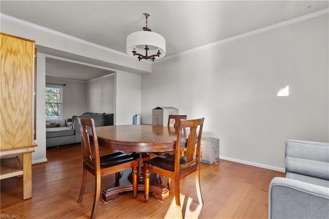 dining space featuring ornamental molding, a chandelier, and hardwood / wood-style flooring