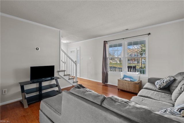 living room with a textured ceiling, ornamental molding, and dark hardwood / wood-style floors