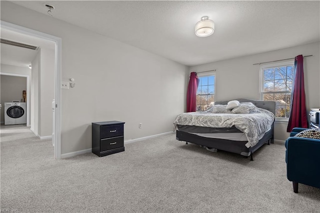 bedroom featuring washer / dryer and light carpet