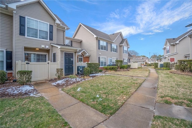 view of front of house featuring a front yard and central AC