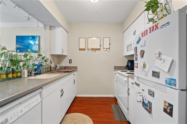 kitchen with white cabinets, dark hardwood / wood-style flooring, sink, and white appliances