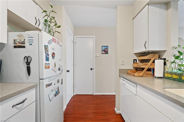 kitchen featuring dark hardwood / wood-style floors, white appliances, and white cabinetry