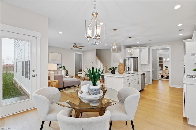 dining room featuring light wood-type flooring, ceiling fan, a healthy amount of sunlight, and sink