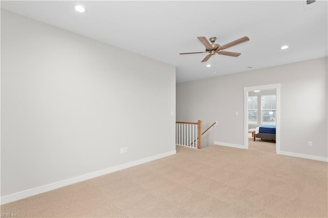 carpeted spare room featuring ceiling fan