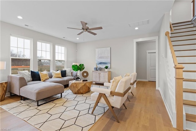 living room featuring light wood-type flooring and ceiling fan