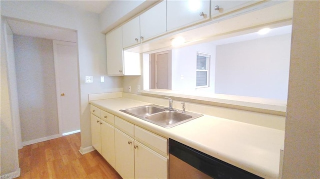 kitchen with dishwashing machine, sink, white cabinetry, and light hardwood / wood-style flooring