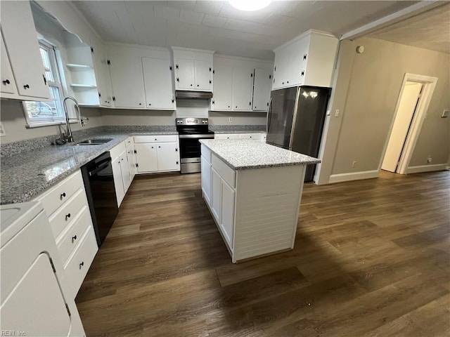 kitchen with appliances with stainless steel finishes, sink, white cabinetry, and a kitchen island