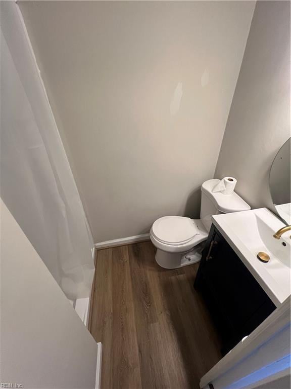 bathroom with toilet, wood-type flooring, and vanity