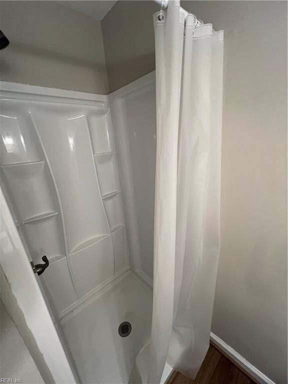 bathroom with a shower with curtain and wood-type flooring