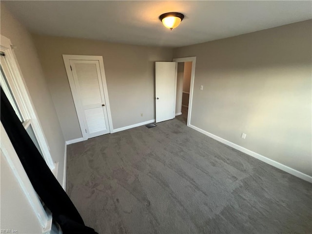 unfurnished bedroom featuring dark carpet