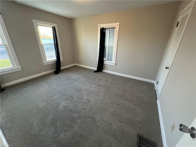 unfurnished room featuring dark carpet