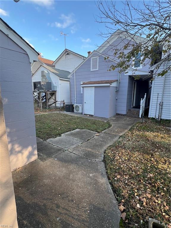 view of side of property with a patio area and central AC