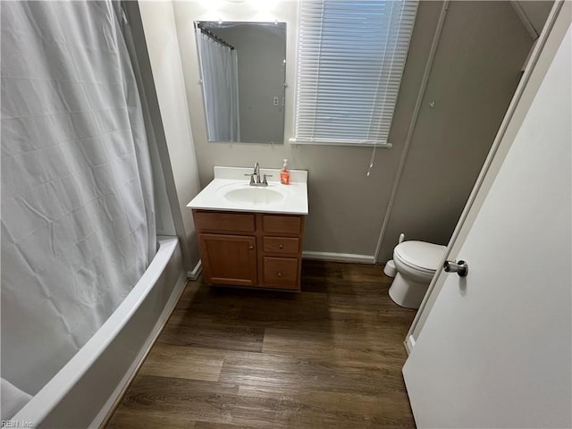 full bathroom with toilet, vanity, wood-type flooring, and shower / tub combo