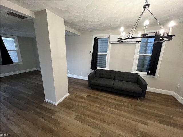 unfurnished room featuring dark wood-type flooring and a notable chandelier