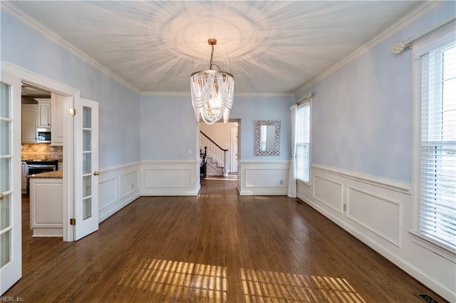 unfurnished dining area with a healthy amount of sunlight, dark hardwood / wood-style flooring, and a notable chandelier