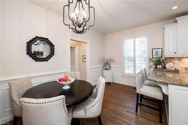 dining room with dark wood-type flooring and a chandelier