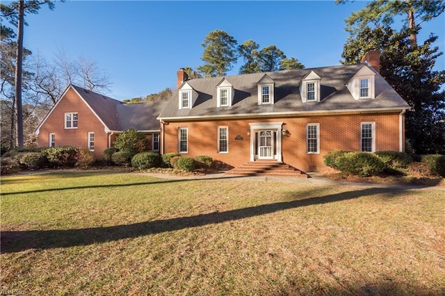 cape cod home featuring a front yard