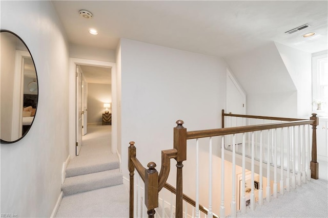 corridor featuring lofted ceiling and light carpet