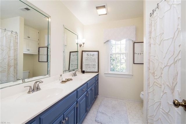 bathroom featuring tile patterned floors, vanity, and toilet