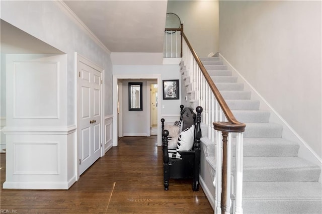 staircase featuring hardwood / wood-style floors and crown molding