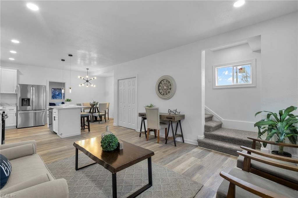 living room featuring light hardwood / wood-style flooring and a chandelier