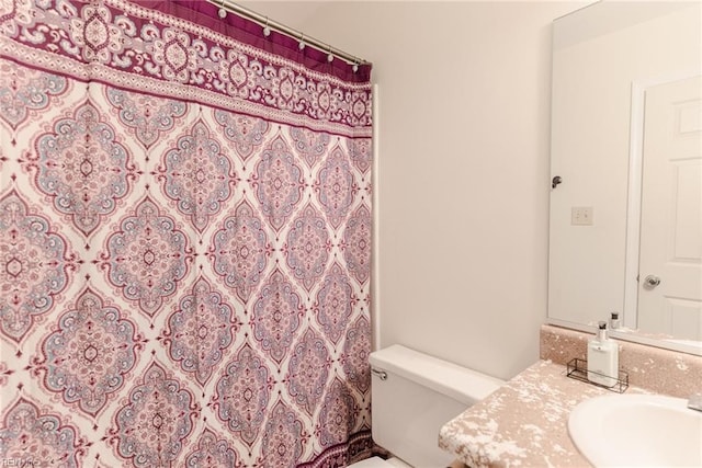 bathroom with toilet, a shower with shower curtain, and vanity