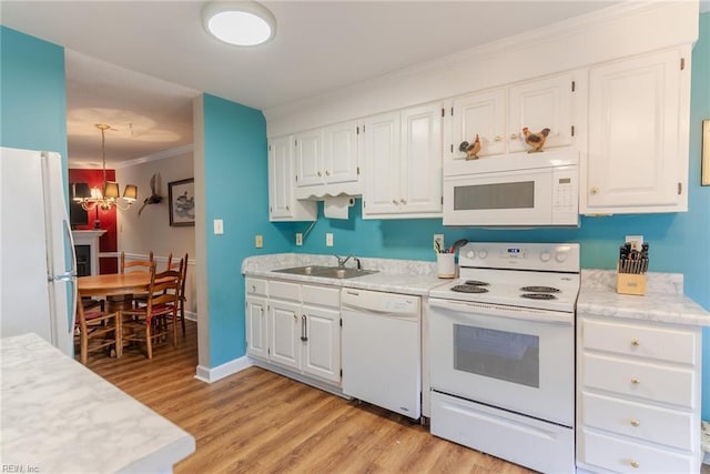 kitchen with white appliances, white cabinetry, light hardwood / wood-style floors, sink, and a chandelier