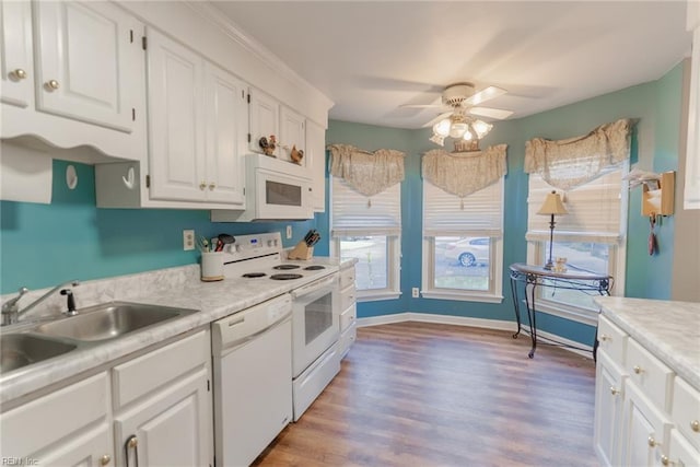 kitchen with white appliances, white cabinetry, sink, ceiling fan, and light hardwood / wood-style flooring