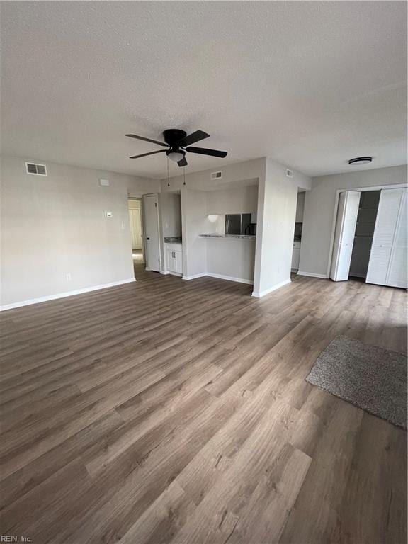 unfurnished living room with ceiling fan, a textured ceiling, and hardwood / wood-style flooring