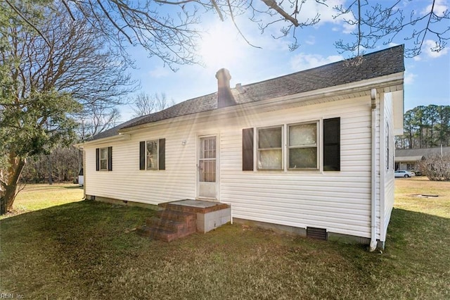 rear view of house featuring a lawn