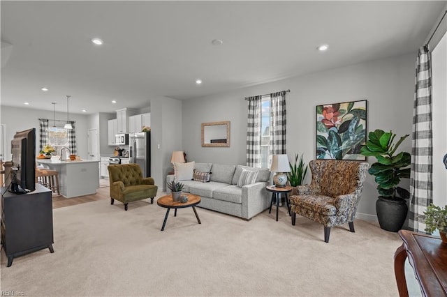 living room featuring sink and light carpet