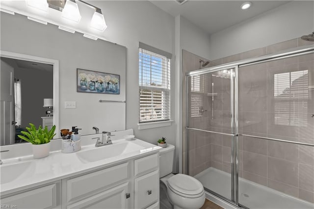 bathroom with toilet, an enclosed shower, and vanity