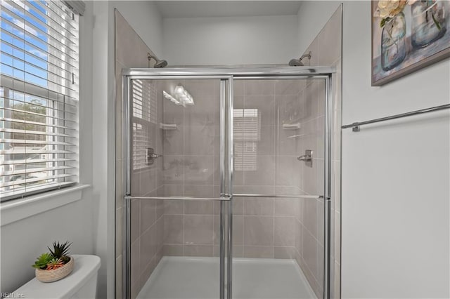 bathroom with toilet and a shower with shower door