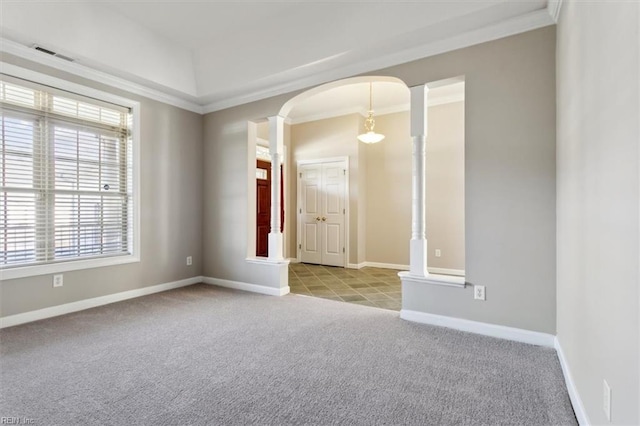 spare room featuring light colored carpet, a raised ceiling, ornamental molding, and ornate columns