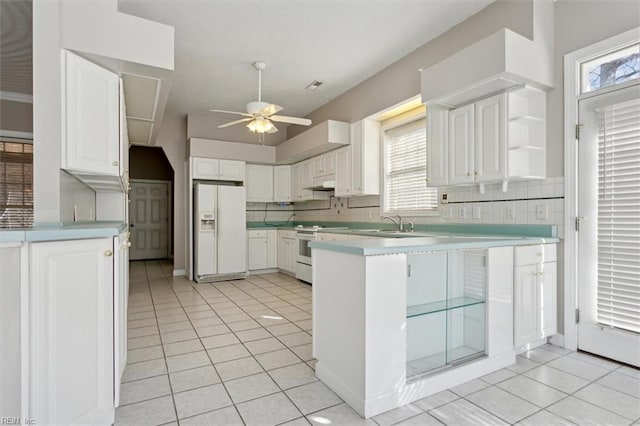 kitchen featuring white appliances, white cabinetry, kitchen peninsula, light tile patterned flooring, and ceiling fan