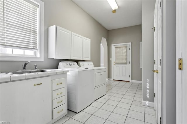 washroom with cabinets, sink, light tile patterned floors, and washing machine and clothes dryer