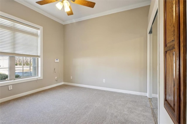 carpeted empty room featuring ceiling fan and ornamental molding