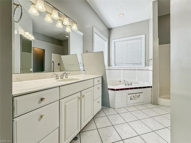 bathroom featuring tiled tub and vanity