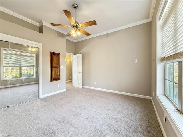 unfurnished bedroom with ceiling fan, a closet, and crown molding