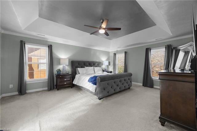 bedroom with light carpet, a tray ceiling, ornamental molding, and ceiling fan