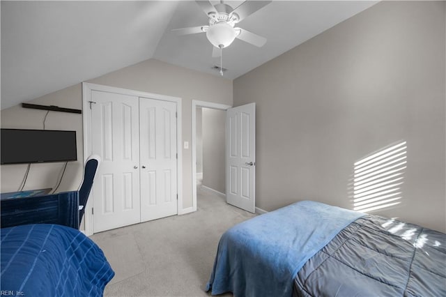 bedroom with lofted ceiling, light colored carpet, ceiling fan, and a closet