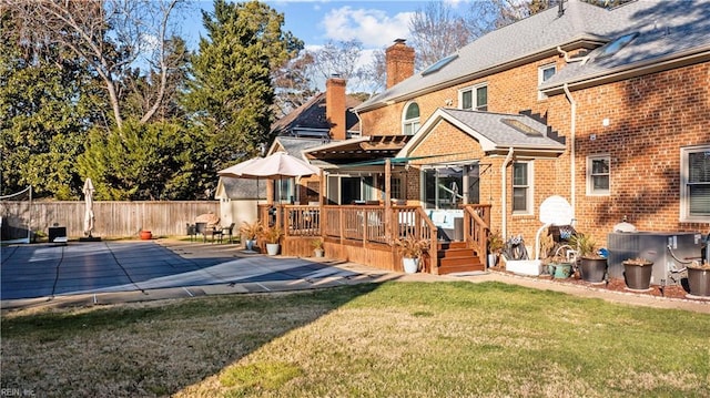 back of property featuring a yard, a deck, and a patio