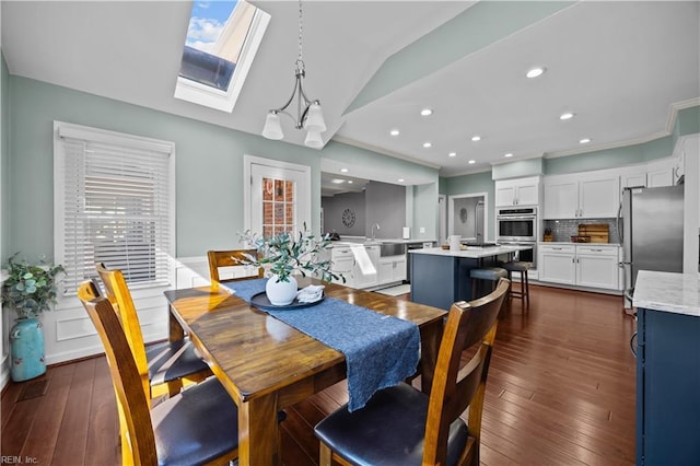 dining room featuring lofted ceiling with skylight and dark hardwood / wood-style floors