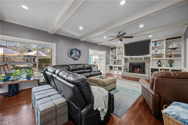 living room featuring built in shelves, a brick fireplace, ornamental molding, dark hardwood / wood-style flooring, and beam ceiling